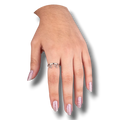Anillo plateado con diseño de gotas de sangre de PartyStore puesto en el dedo de una mano con uñas brillantes