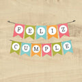 Banderín PartyStore con letras FELIZ CUMPLE en colores vibrantes sobre fondo de madera para decoración de fiestas