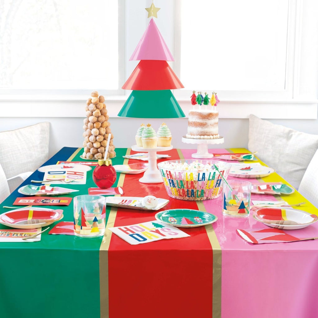 Mesa decorada de PartyStore con platos coloridos, servilletas navideñas y vajilla festiva para una fiesta temática.