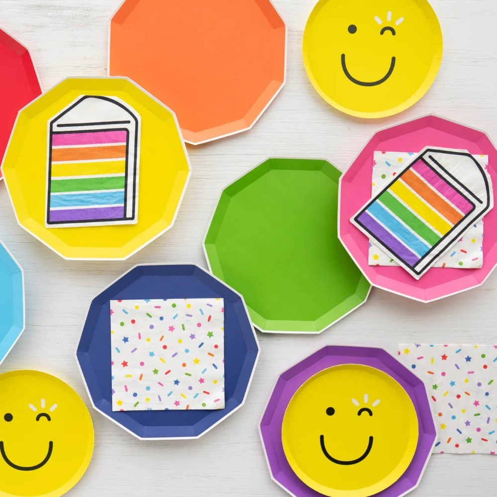 Servilletas PartyStore con diseño de chispas de colores y caritas felices sobre platos de fiesta octogonales